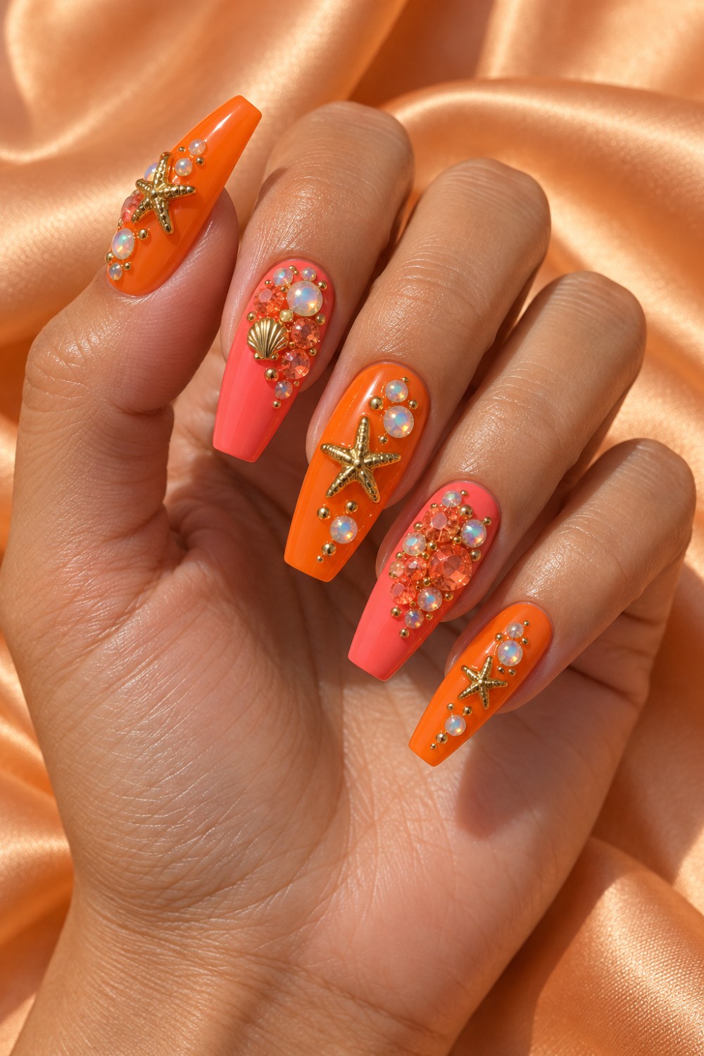 Tangerine and coral polish with gold stars and orange gems.